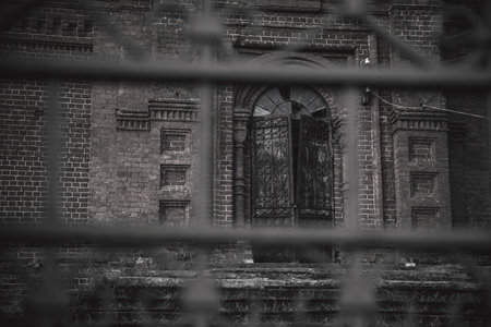 An old beautiful and scary abandoned church. Brick walls. Gloomy gothic atmosphere. Evening light.の写真素材