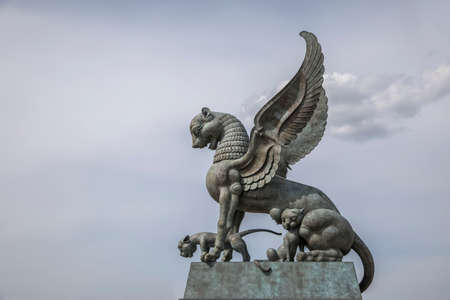 Beautiful bronze dragon statue in the street. It's a nasty day. Beautiful architecture.