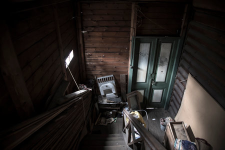 Beautiful and gloomy interior of an old abandoned house. Antique staircase and wooden door. Shabby...