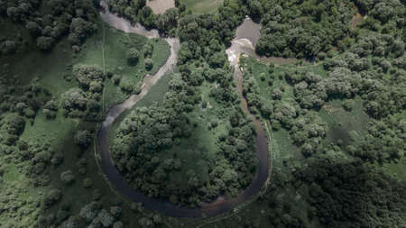 A beautiful bend of the river from above. Green Park. Beautiful trees. The sun's rays are reflected from the ground and water.の写真素材