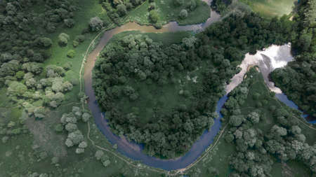 A beautiful bend of the river from above. Green Park. Beautiful trees. The sun's rays are reflected from the ground and water.の写真素材