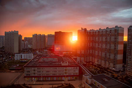 Beautiful and colorful sunset behind the houses in the cityの写真素材