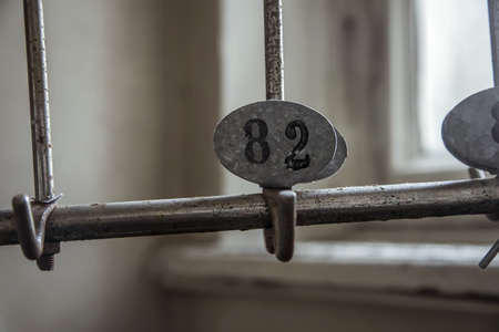 An old rusty number on a gardirob in an abandoned hospital. The window is in the background. Abandoned building.の写真素材