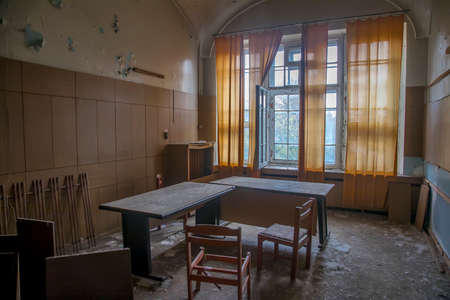 An old room in an abandoned hospital. Big window. Light passing through the window. Shabby walls. The interior of an abandoned building.の写真素材