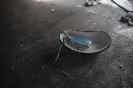 Old medical instruments lie on the floor. An old abandoned hospital.の写真素材