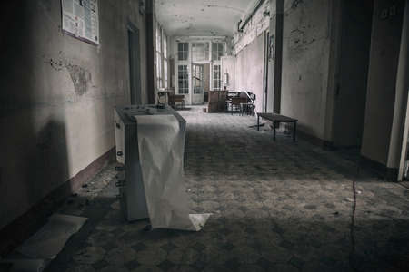 Scary empty dark corridor in an abandoned building. Shabby walls. The play of light and shadows in an abandoned house. Broken doors. An old abandoned hospital. The interior of an abandoned house.の写真素材