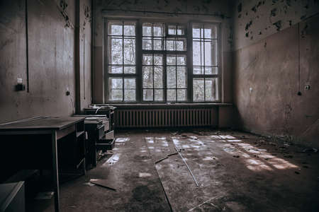 An old room in an abandoned hospital. Big window. Light passing through the window. Shabby walls. The interior of an abandoned building.の写真素材