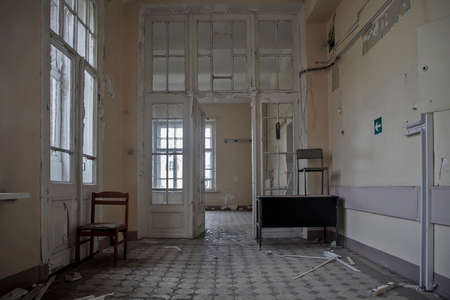 A beautiful corridor with doors in an abandoned hospital. Street outside the window. Old shabby walls. The interior of an abandoned building. Wooden doors.の写真素材