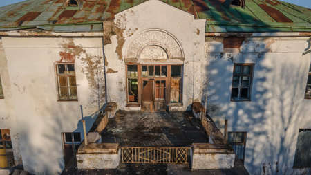 A beautiful balcony on the second floor of an old abandoned manor. White walls. Evening light. Ancient architecture.の写真素材