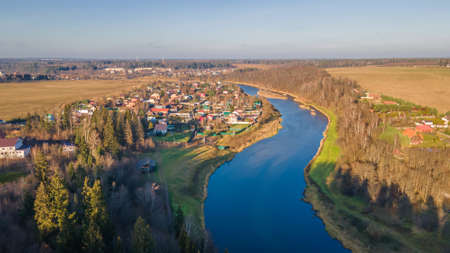 Beautiful evening landscape. Autumn nature. Wide river with blue water. Sunny autumn evening.