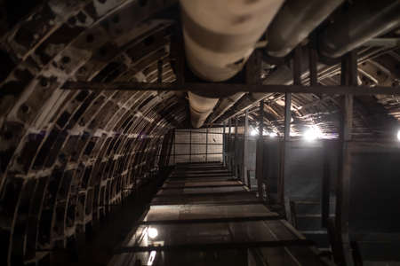 An old mine going up in an abandoned underground bunker. long vertical tunnel. Dim lamps.の写真素材