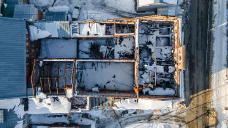 A drone view of the ruins of an abandoned ancient building in the snow. Winter snowy sunny day. old abandoned house.の写真素材
