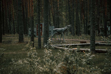 Abandoned animal statue in the forest. Old abandoned pioneer camp. mysterious forest. Grass and trees.の写真素材