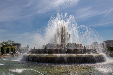 Nice and big fountain. Splashes of water. Sunny summer day. colorful architecture. blue sky.の写真素材
