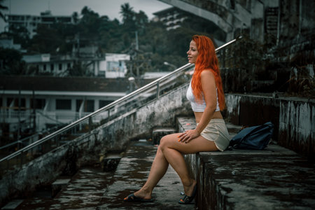 Beautiful young redhead woman sitting on the bridge in Bangkok, Thailand