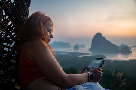 Young woman sitting on a chair and using a smart phone at sunrise.