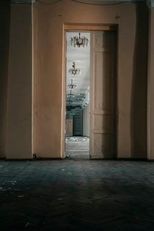 Interior of an old abandoned building with wooden doors and white walls