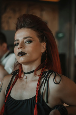 Portrait of young woman with red braids in a black dressの写真素材