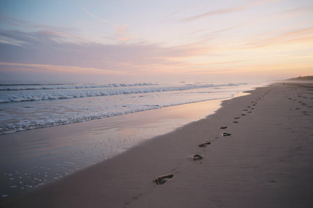 Footprints in the sand on the beach at sunset. Beautiful landscape.の素材
