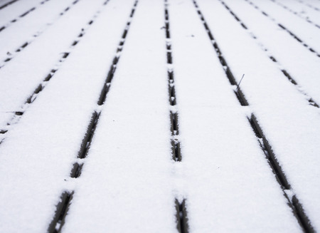 Wooden deck covered with snow converging lines with shallow depth of field