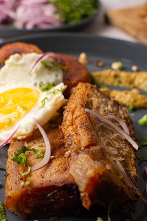 Pork belly with fried egg. Fried pork. Ecuadorian cuisine. Grill.の写真素材