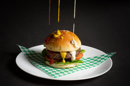 Homemade hamburger on a plate on a dark background. Selective focus.の写真素材