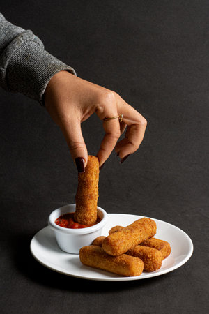 croquettes with sauce on a white plate on a black backgroundの写真素材