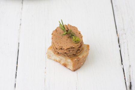 Pate on a slice of bread on a rustic wooden background