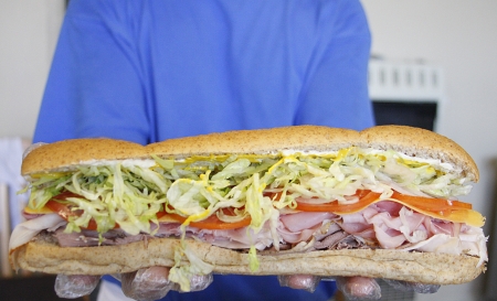 Hands holding a huge sub sandwichの写真素材