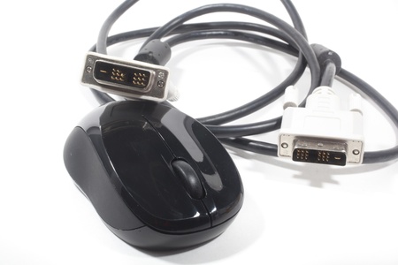 A black wireless mouse and a VGA cable isolated against a white background