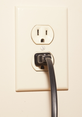 A plug connected to an electrical outletの写真素材