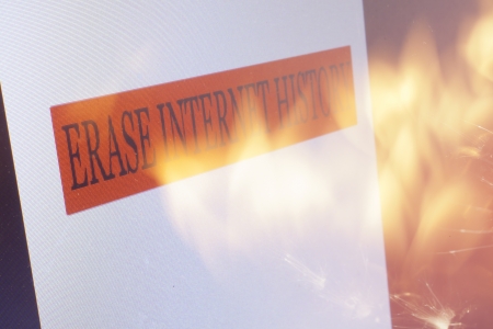 An Erase Internet History sign on a computer screen and flames from a  fire.の写真素材
