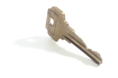 A key with a drop shadow isolated against a blank 