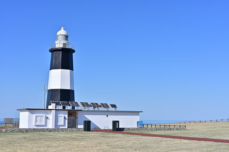 Lighthouse and solar panels against blue sky on a sunny day.の写真素材