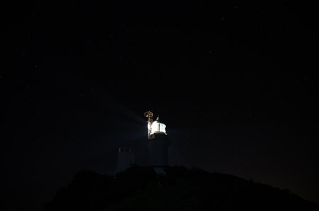 Lighthouse at night with starry sky and stars in the backgroundの写真素材