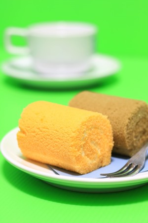 cake roll and coffee on green background.の写真素材