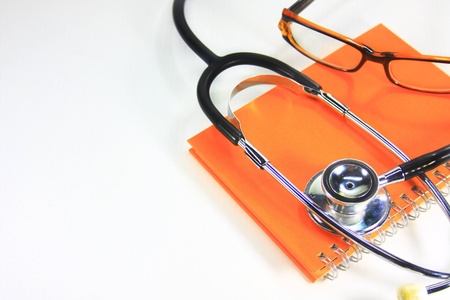 stethoscope on orange note bookの写真素材