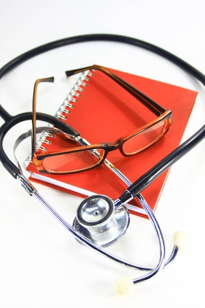 stethoscope and glass on orange note note bookの写真素材