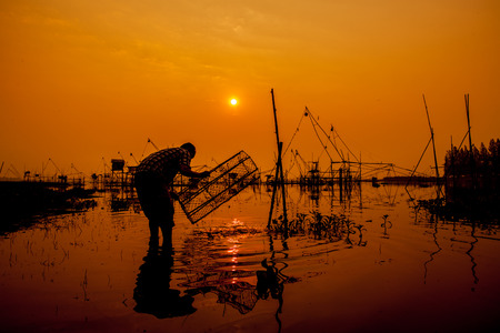 Silhouette of a man fishingの写真素材