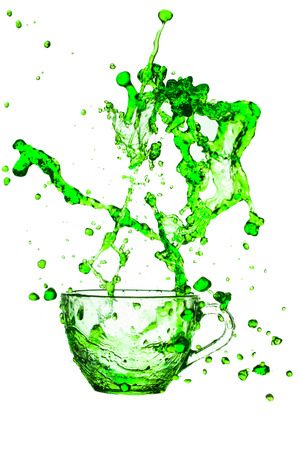 green splashes out drink from glass on a white background の写真素材