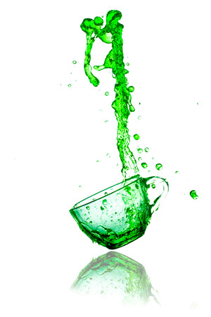 green splashes out drink from glass on a white background の写真素材