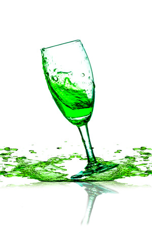 green beverage splash out of the glass の写真素材