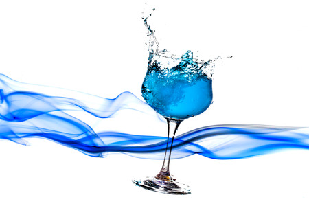 blue water splash from glass on white background.の写真素材
