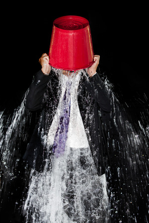 Man pour out bucket of water pouring himself.の写真素材