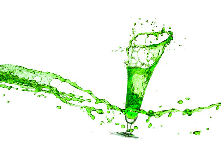 green water splash from glass on white background.の写真素材
