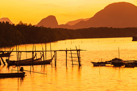 The wooden fishing boat With the morning light southern Thailand.の写真素材