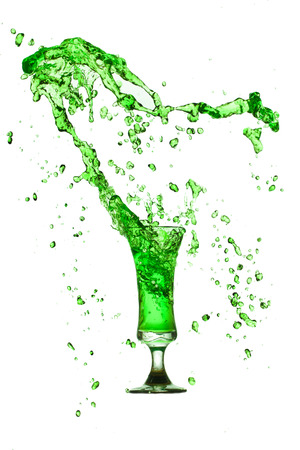 Drink green splash out of glass on a white background.の写真素材