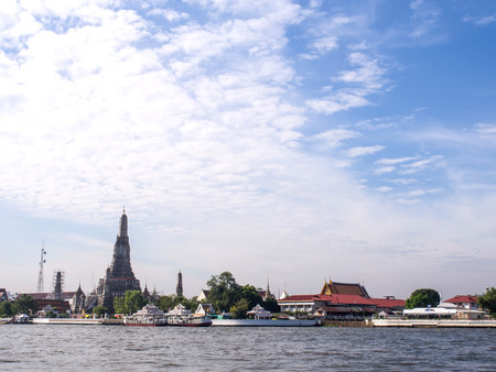 Grand stupa of Dawn temple near Chaophraya river under cloudy sky in Bangkokの写真素材