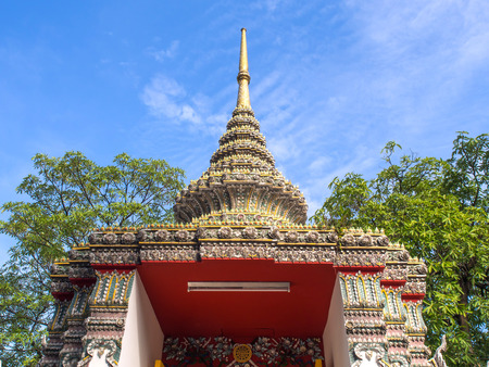 Delicate Thai art at top and roof of church in Wat Pho under blue sky, Bangkok, Thailandの写真素材
