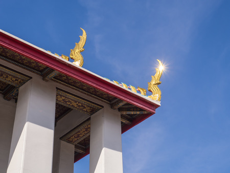 Delicate Thai art at top and roof of church in Wat Pho under blue sky, Bangkok, Thailandの写真素材